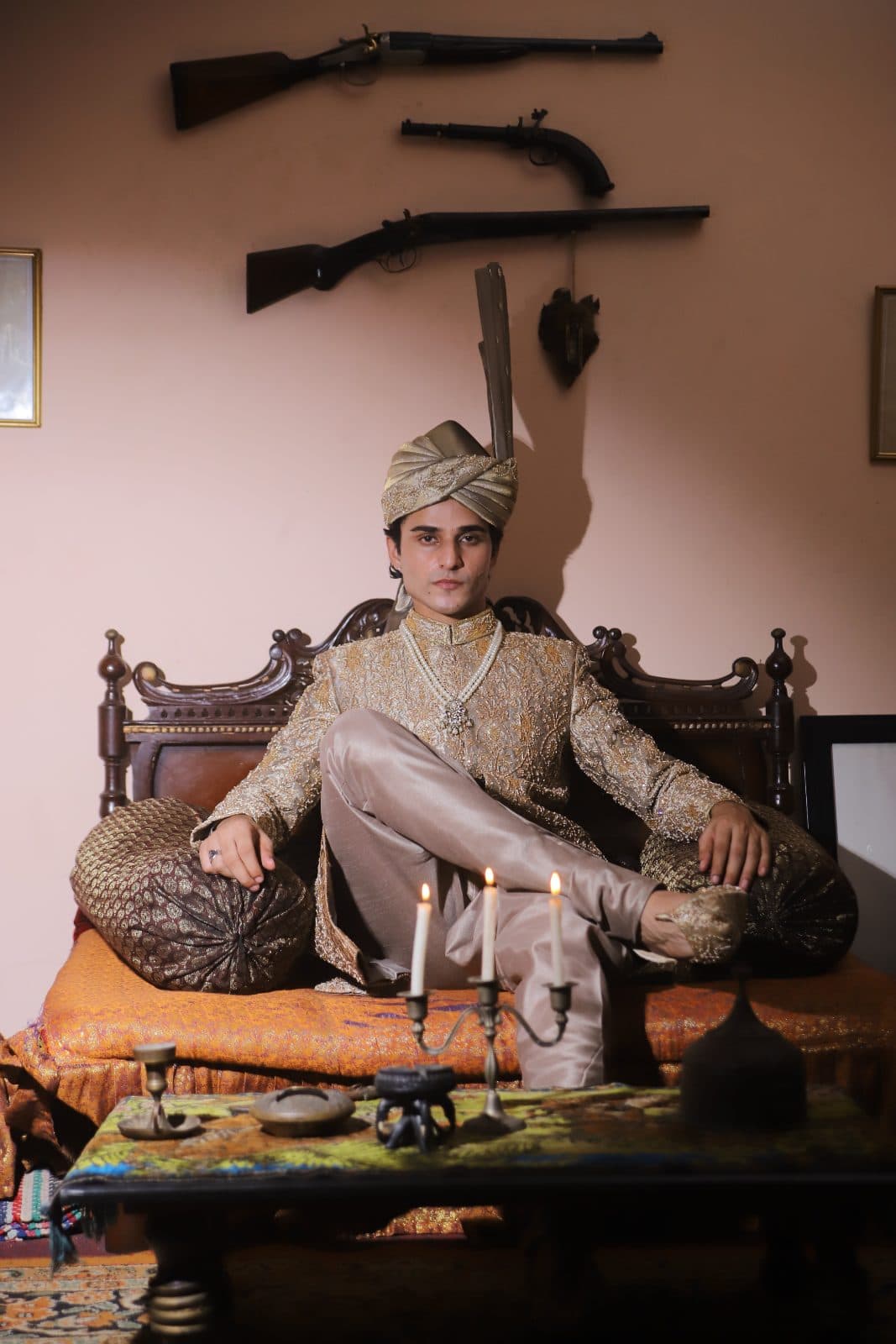 Kudmayi Noor E Sultan antique-gold sherwani styled with a matching turban in a heritage interior.